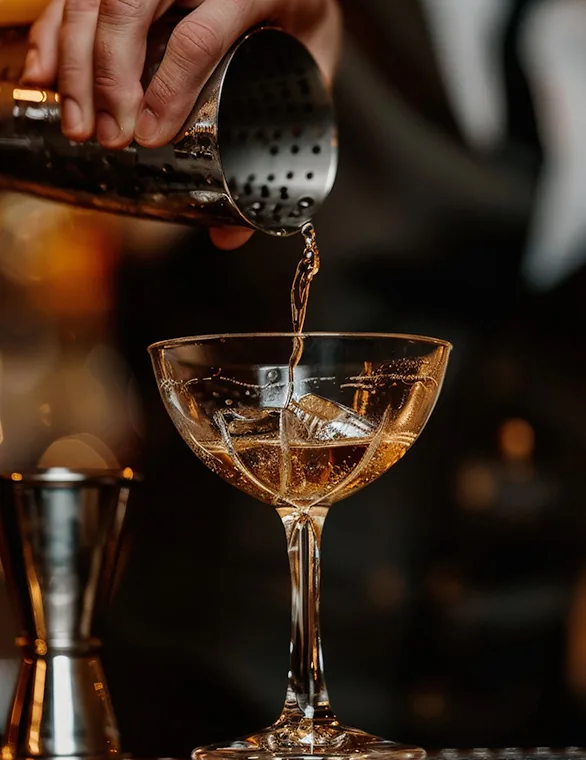 Bartender sirviendo Sōber en copa desde la coctelera